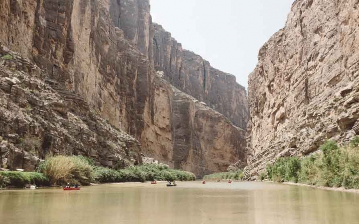 canoes are paddled on calm water between very high canyon walls on an outward bound gap year semester